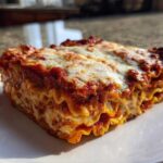 A thick, cheesy slice of amazing lazy lasagna showing layers of pasta, sauce, and ricotta filling.