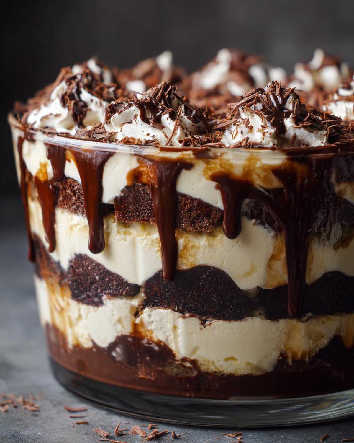 Close-up of a layered Baileys Chocolate Cheesecake Trifle with chocolate cake, cream filling, and chocolate drizzle.