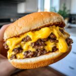 Close-up of a juicy double cheeseburger dripping with melted cheese, enhanced by the secret burger sauce.