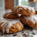 A stack of four soft, spiced persimmon cookies topped with a thick white glaze.