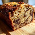 Close-up of a moist chocolate chip banana bread recipe loaf, showing the crumb texture and melted chocolate chips.