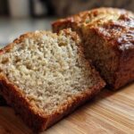 Close-up of a moist slice of greek yogurt banana bread showing its tender crumb and golden-brown crust.