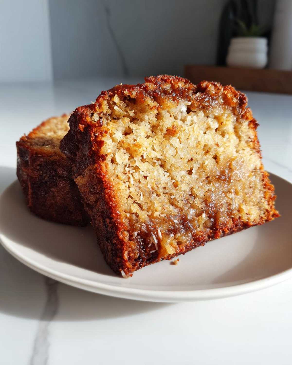 Close-up of two moist slices of hawaiian banana bread showing a rich, caramelized crust and soft interior.