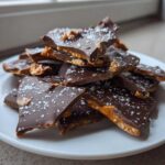 A pile of broken pieces of peanut butter pretzel bark, topped with sea salt flakes.