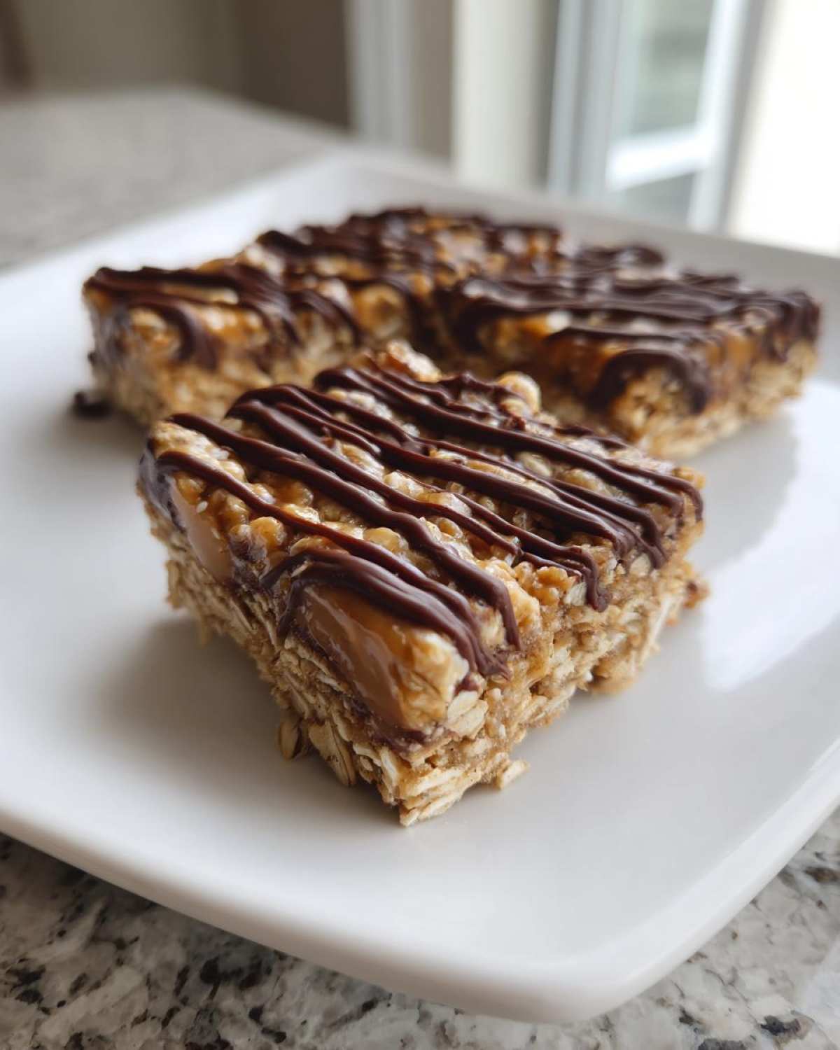 Close-up of a homemade protein bars square topped with caramel and drizzled with dark chocolate.