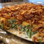 Close-up view of a creamy green bean casserole topped generously with crispy fried onions.
