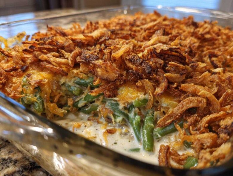 Close-up view of a creamy green bean casserole topped generously with crispy fried onions.