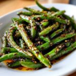 Close-up of vibrant green beans coated in a savory, spicy Chinese green beans with garlic sauce.