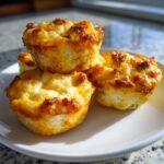 A stack of four golden-brown cottage cheese egg cups starbucks style on a white plate.