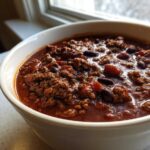 Close-up of a rich, hearty bowl of chili loaded with ground beef and kidney beans, perfect for the best chili recipe.
