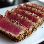 Close-up of perfectly cooked Seared Ahi Tuna, sliced and crusted with black and white sesame seeds.