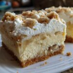 A decadent slice of Banana Pudding Cheesecake Bars showing graham cracker crust, creamy layers, and whipped topping.