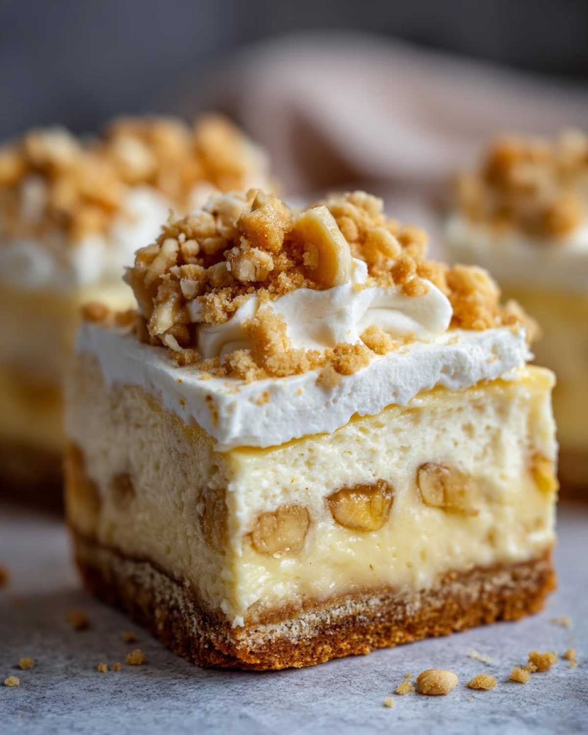 A perfect square slice of Banana Pudding Cheesecake Bars with a graham cracker crust, creamy filling, and crumb topping.
