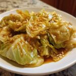 Close-up of tender cabbage wedges coated in a glossy garlic ginger sauce, ready to serve.