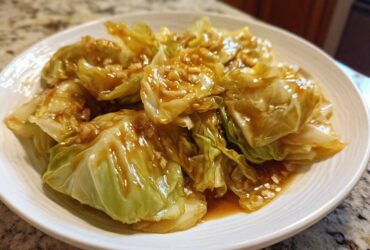 Close-up of tender cabbage wedges coated in a glossy garlic ginger sauce, ready to serve.