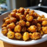 A close-up of a white bowl filled with golden, seasoned Crunchy Air Fryer Ranch Chickpeas.