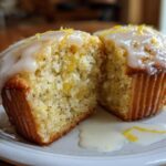 Close-up of Glazed Lemon Poppy Seed Muffins cut open, showing moist interior and dripping lemon glaze.