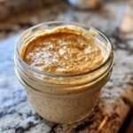 Close-up of creamy High-Protein Peanut Butter Overnight Oats mixed with chia seeds in a glass jar.