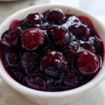 Close-up of plump blueberries simmering in thick, dark juice, perfect for Homemade Blueberry Syrup.