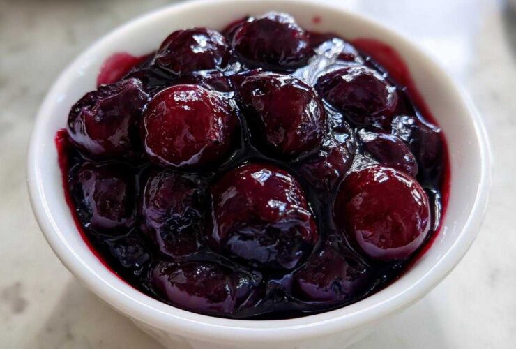 Close-up of plump blueberries simmering in thick, dark juice, perfect for Homemade Blueberry Syrup.