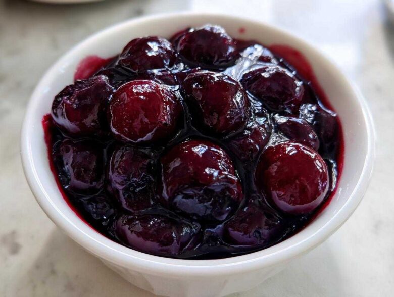 Close-up of plump blueberries simmering in thick, dark juice, perfect for Homemade Blueberry Syrup.