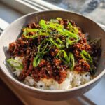 A close-up of Korean Ground Beef Bulgogi Bowls featuring savory ground beef over white rice, topped with green onions and sesame seeds.