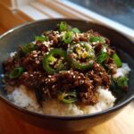 Close-up of Korean Ground Beef Bulgogi Bowls served over white rice, topped with jalapeños and sesame seeds.