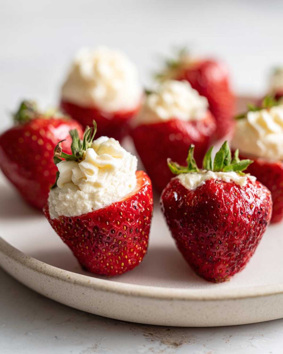 Close-up of fresh strawberries filled with creamy white no-bake cheesecake mixture.