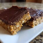 Close-up of rich No-Bake Chocolate Peanut Butter Oat Bars showing the thick oat base and chocolate topping.