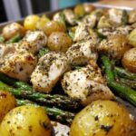 Close-up of Sheet Pan Lemon Pepper Chicken and Potatoes with roasted asparagus.