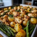 Close-up of perfectly roasted Sheet Pan Lemon Pepper Chicken and Potatoes with asparagus on a baking tray.