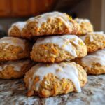 A stack of delicious Soft-Baked Carrot Cake Cookies topped with dripping cream cheese glaze.