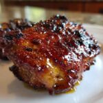 Close-up of a perfectly cooked Spicy Honey Garlic Air Fryer Chicken Thigh with a thick, caramelized glaze.