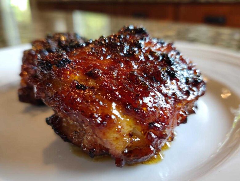 Close-up of a perfectly cooked Spicy Honey Garlic Air Fryer Chicken Thigh with a thick, caramelized glaze.