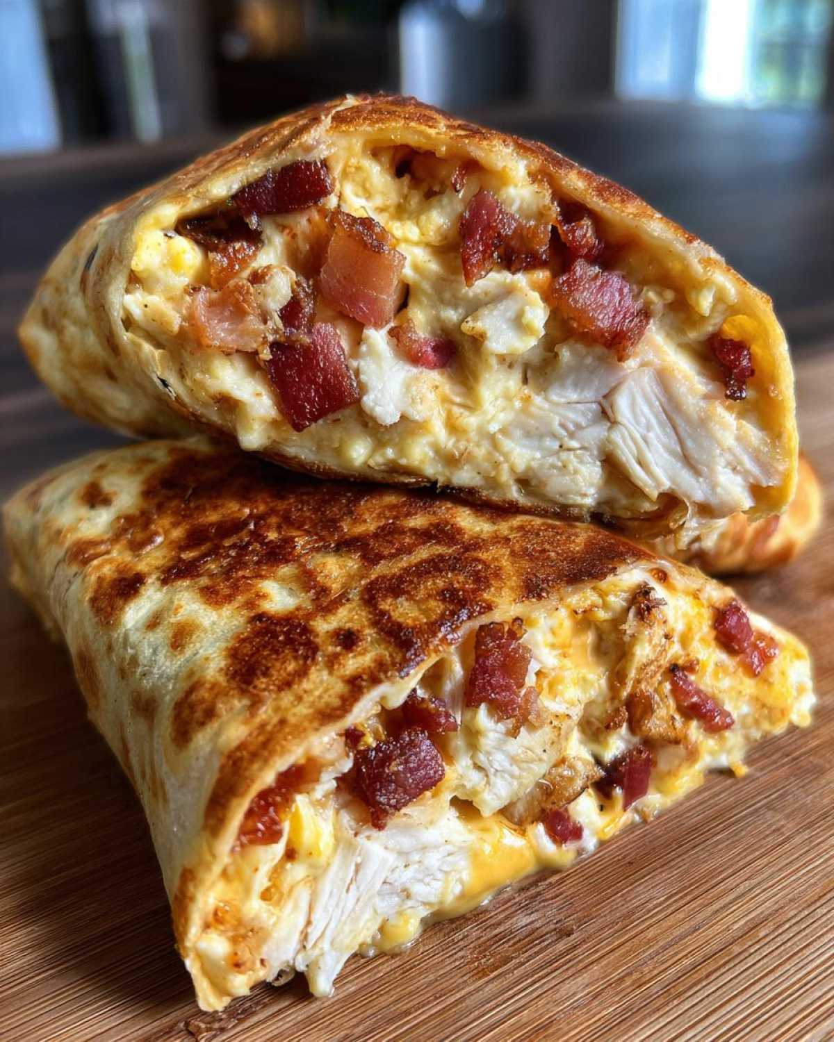 Cross-section view of Air Fryer Crispy Chicken Bacon Ranch Wraps stuffed with chicken, bacon, and creamy ranch filling.