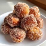 A close-up pile of golden brown Air Fryer Crispy Cinnamon Sugar Pretzel Bites coated heavily in sparkling sugar.