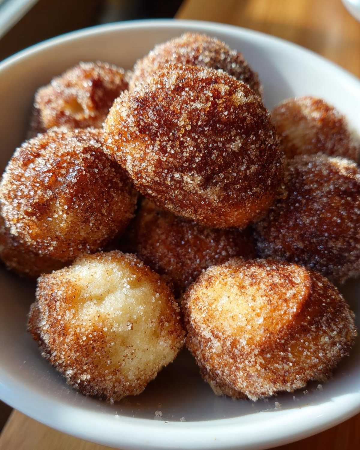 Close-up of golden Air Fryer Crispy Cinnamon Sugar Pretzel Bites heavily coated in sparkling cinnamon sugar.