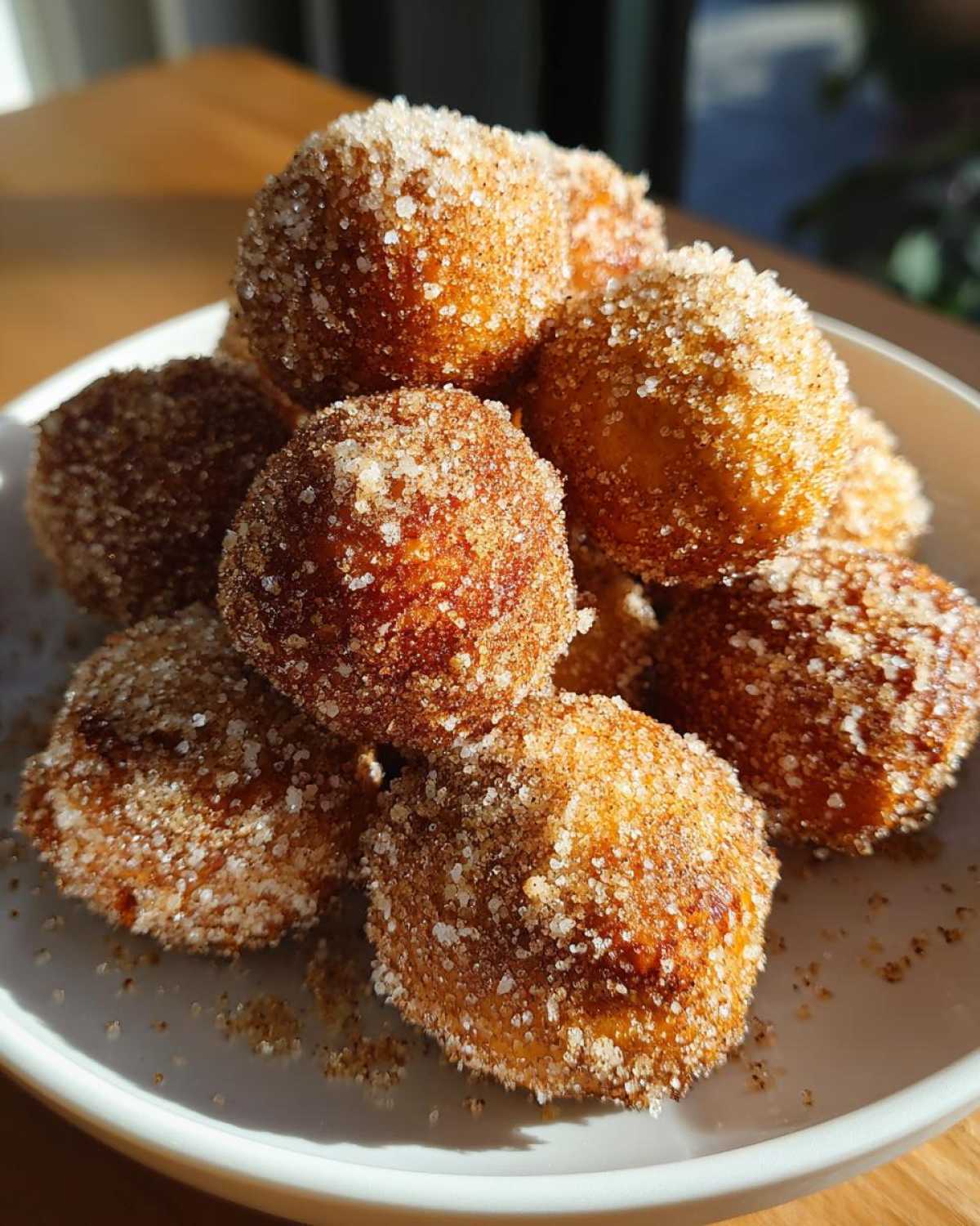 Close-up of golden brown Air Fryer Crispy Cinnamon Sugar Pretzel Bites piled high and coated in sparkling sugar.