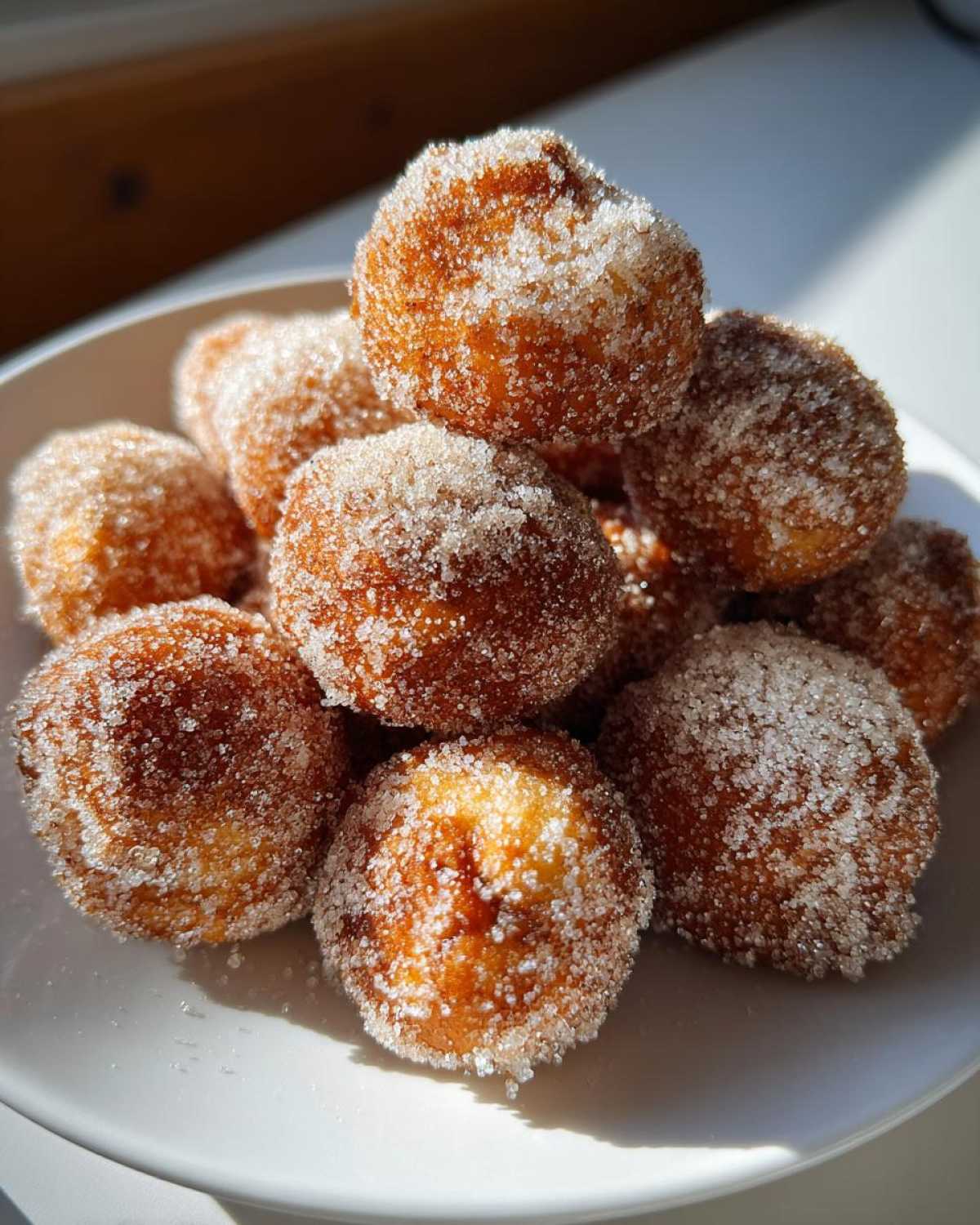A pile of golden brown Air Fryer Crispy Cinnamon Sugar Pretzel Bites heavily coated in sparkling sugar.