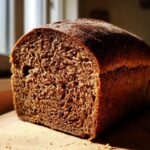 A close-up view of the rich, dark brown crumb texture of the Copycat Dark Brown Honey Wheat Bread.