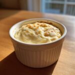 A single serving of creamy, baked Copycat Pizza Garlic Parmesan Dip Sauce in a white ramekin.