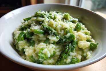 Close-up of Easy Creamy Asparagus Risotto topped with grated Parmesan cheese in a white bowl.