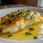 Close-up of a perfectly cooked Easy Flounder Francese Recipe fillet swimming in bright lemon butter sauce and topped with fresh parsley.