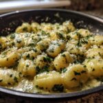 Close-up of Easy One-Pan Creamy Garlic Butter Gnocchi coated in sauce, topped with parsley and Parmesan.