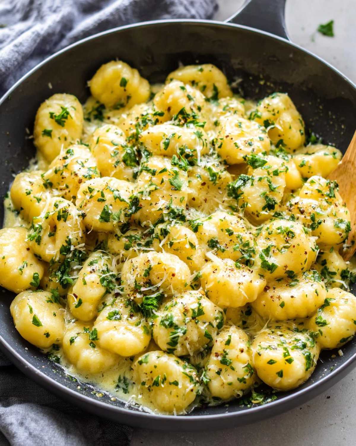 Close-up of Easy One-Pan Creamy Garlic Butter Gnocchi coated in sauce and topped with parsley.