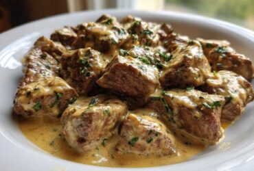 Close-up of Easy One-Pan Creamy Garlic Steak Bites covered in rich sauce and sprinkled with parsley.