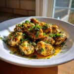 A plate of glistening Garlic Butter Chicken Bites generously topped with fresh chopped parsley.