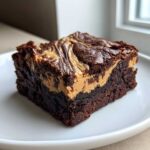 A rich square of Gluten-Free Chocolate Peanut Butter Swirl Brownies on a white plate.