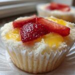 Close-up of a Gluten-Free Lemon Strawberry Angel Food Cup topped with fresh strawberries and lemon glaze.