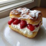 A single Gluten-Free Strawberry Cream Cheese Danish filled with cream and fresh strawberries, dusted with powdered sugar.